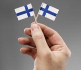 Två finska flaggor i en hand. Foto: Colourbox
