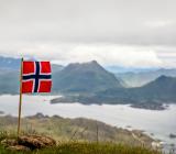Norska flaggan med fjord i bakgrunden. Foto: Colourbox
