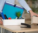 Person samlar sina saker i en låda på kontor. Foto: Colourbox