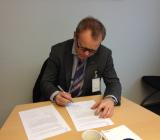 Caverions Norgechef Knut Gaaserud signerar storaffären med Försvarsbygg. Foto: Caverion
